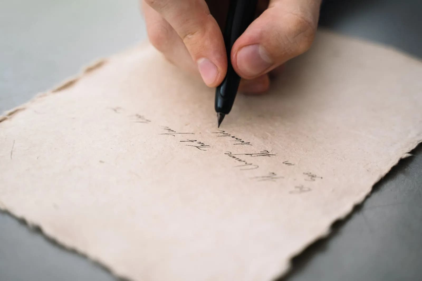 A hand writing on paper with a pen